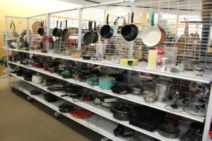 Kitchen products, including pots and pans, resting on shelves.