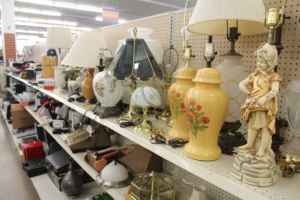 Lamps, clocks and other homeware goods on shelves.