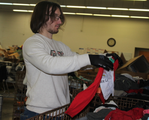 A YSU volunteer searches for clothing items that will be sold.