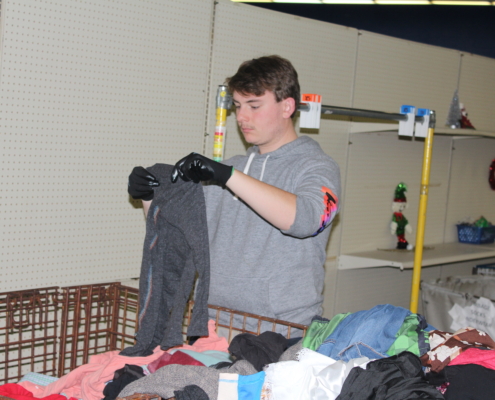 A YSU volunteer searches for clothing items that will be sold.